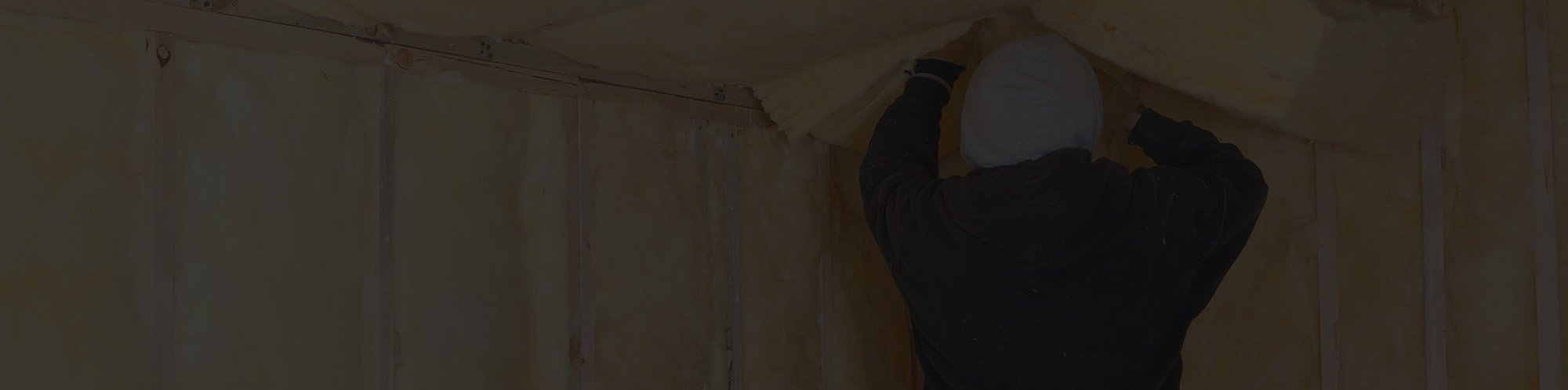 Roofing contractor installing attic insulation in Massachusetts home